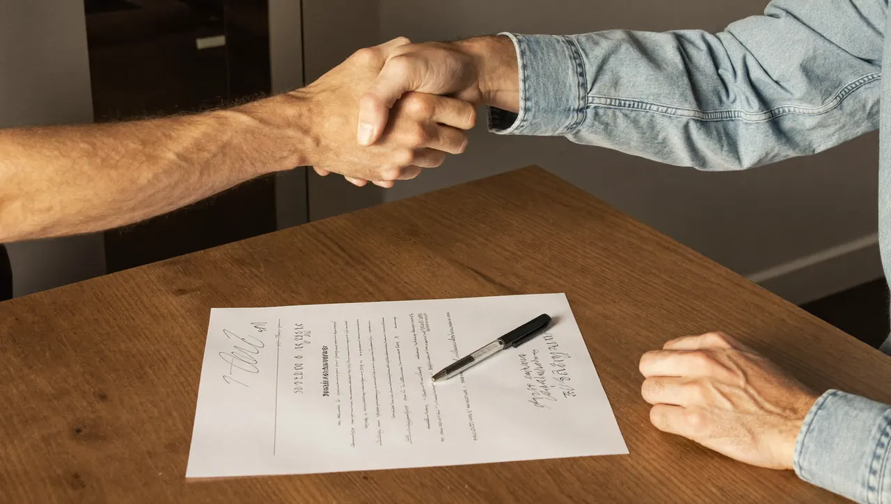 Homeowner and installer shaking hands over a signed contract